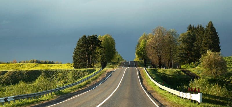 Yeşil tepelerin arasından ufka uzanan iki şeritli yol